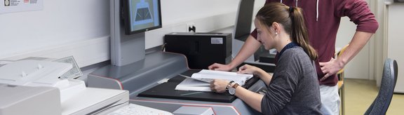 Studierende arbeiten am Scanner in der Hauptbibliothek