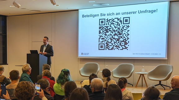 DiSCussion: What can AI do? Andreas Eckhardt gives a presentation with slides on stage