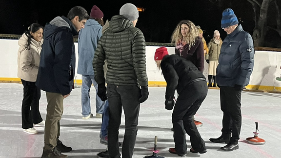 People stand around a group of ice sticks and examine their positions